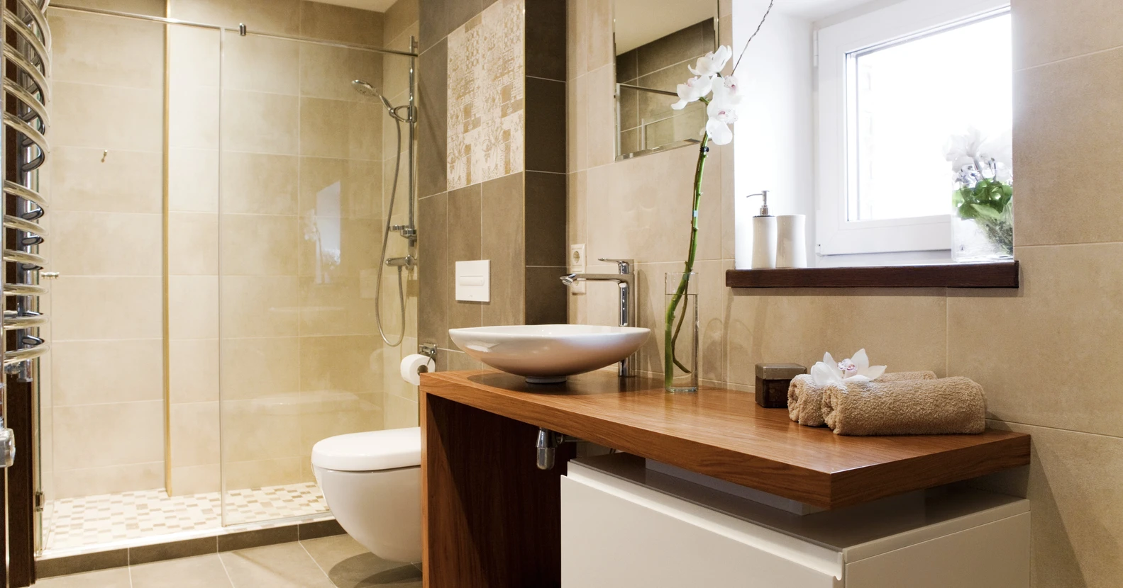 Salle de bain moderne avec douche à l'italienne ouverte, carrelage métro blanc au mur, colonne de douche chromée avec pommeau et douchette